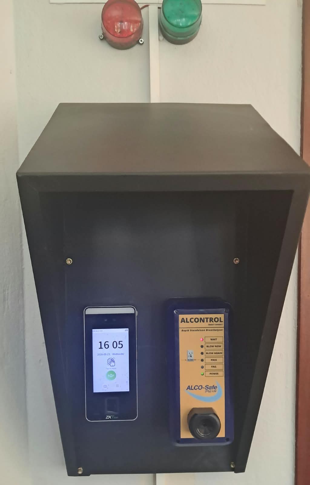 Installed ALCONTROL breathalyzer unit under a protective hood, with reader, status lights and blow nozzle